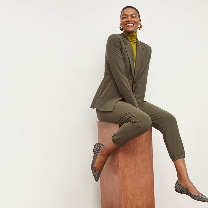 Front image of a woman standing wearing the Delaney Jogger—OrigamiTech in Olive