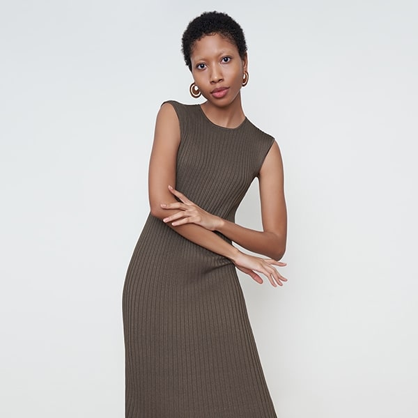 Front image of a woman standing wearing the dylan dress in safari | Exclude