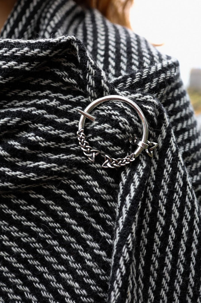 Woven Celtic shawl in black and white with silver Trinity knot brooch and fringe detail