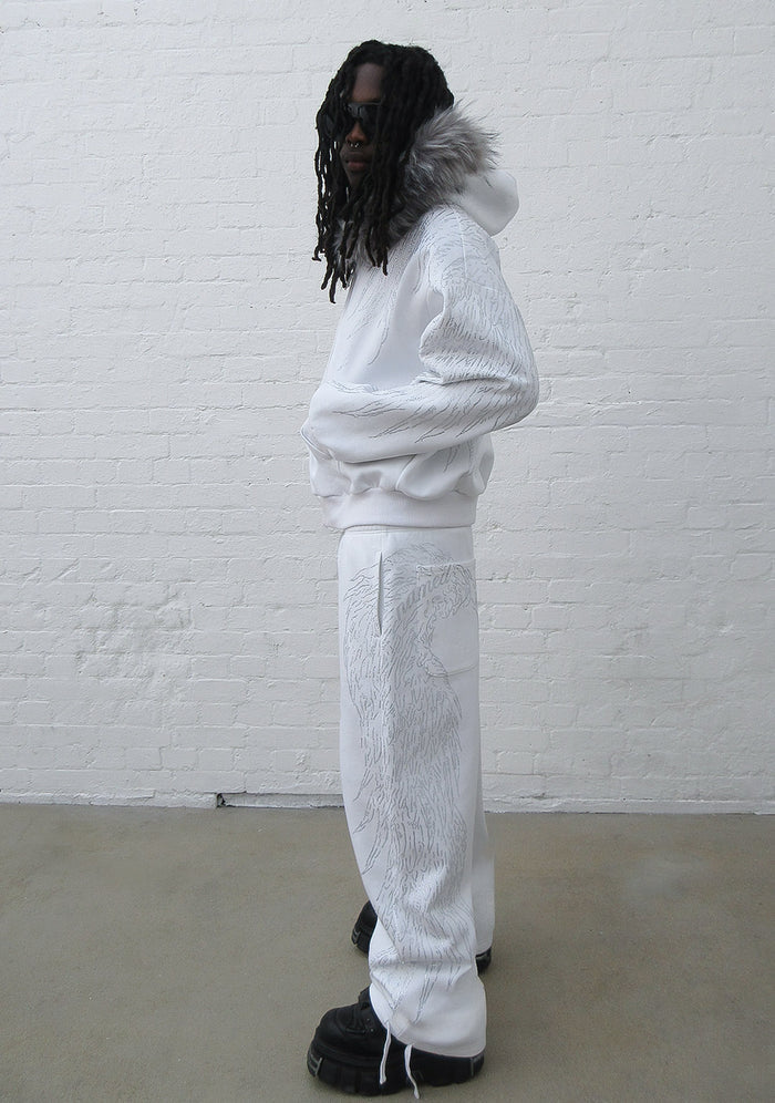 Model wearing a white hoodie with rhinestone design and detachable fur trim, side view.