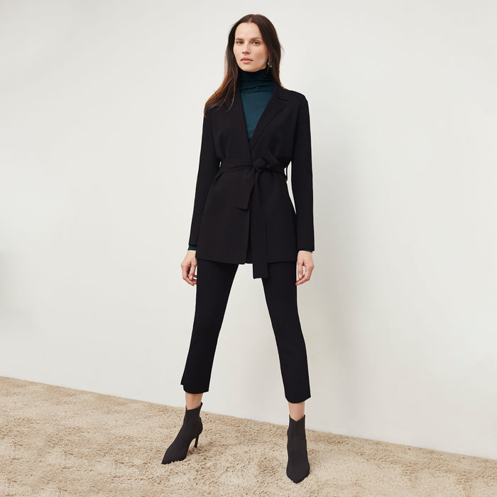 Front image of a woman standing wearing the Finley Legging—Ribbed Jardigan Knit in Black