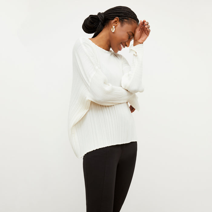Side image of a woman wearing the Lasha Top - Micro Pleat in Ivory