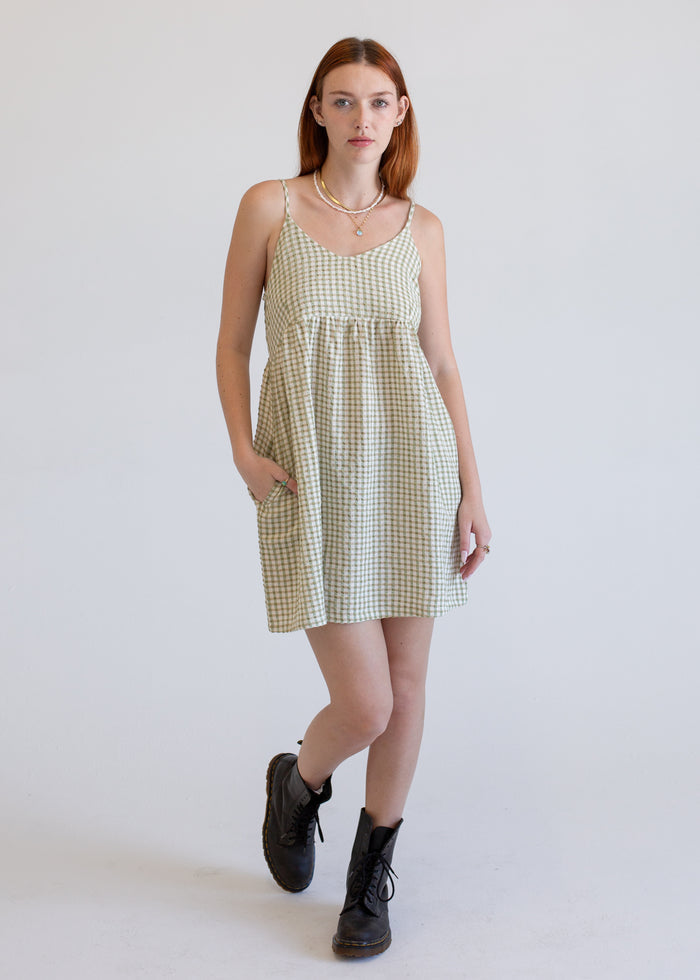 Woman wearing a checkered dress with a plain background