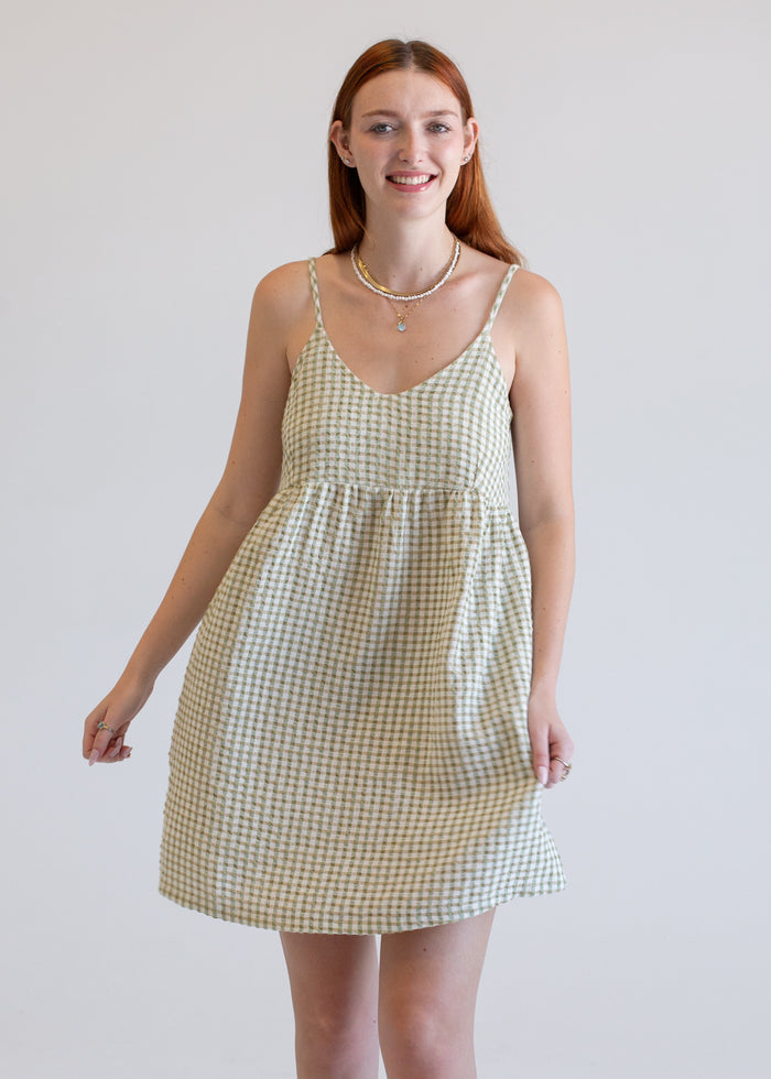 Woman wearing a checkered dress against a plain background