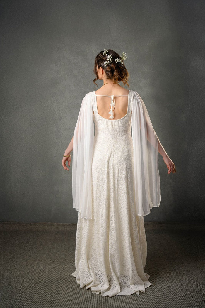 Back view of ivory lace regency wedding dress with open back, tie detail and long chiffon drape sleeves