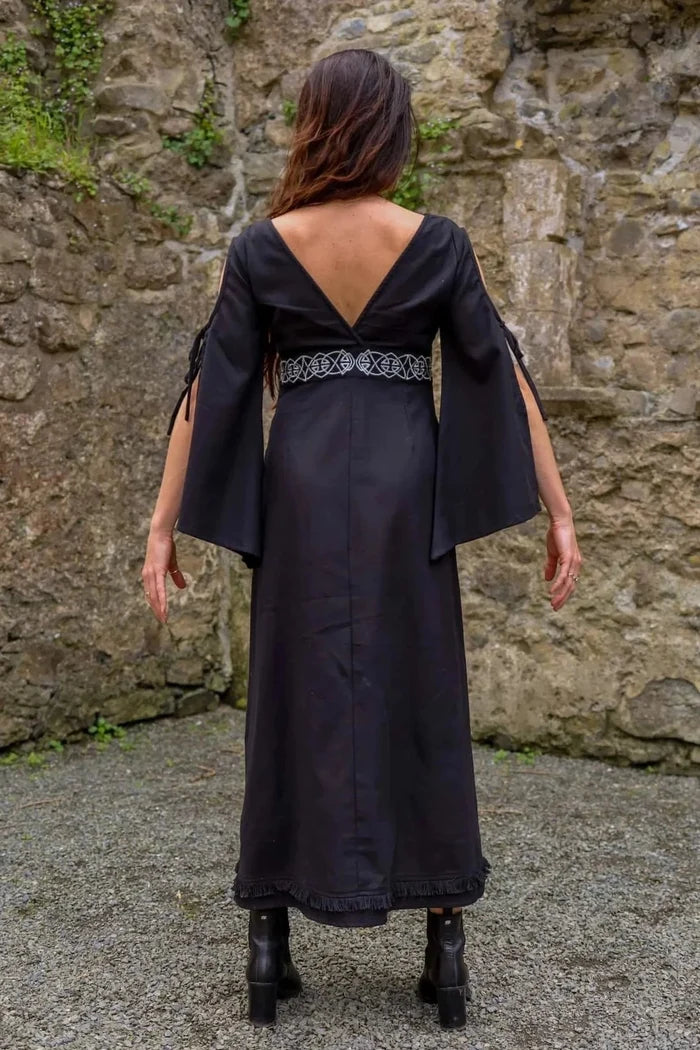 Back view of Maeve Black Celtic Dress, dark romantic dress with bell sleeves, plunging back and full length silhouette