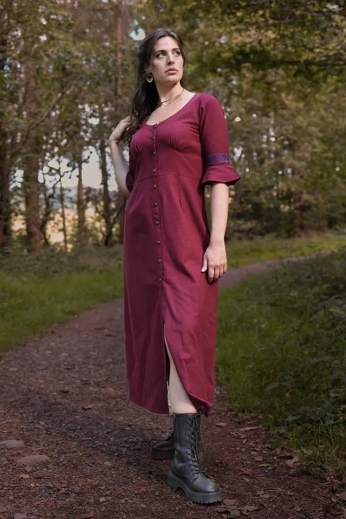 Burgundy Celtic maxi dress with Celtic embroidered sleeves worn on a woodland path