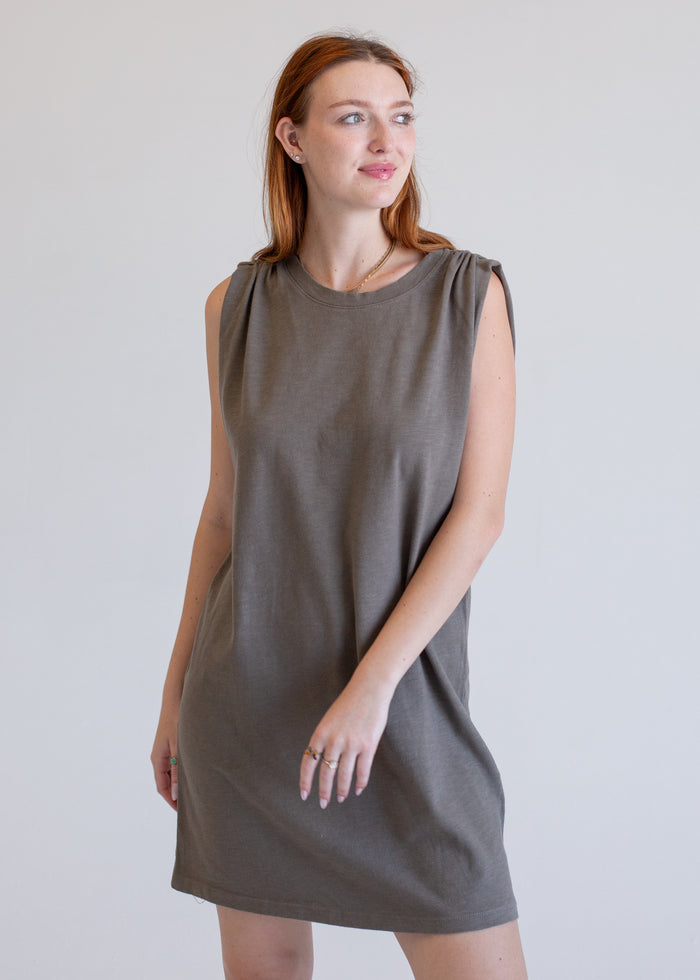 Woman wearing a gray boxy tank dress against a plain background