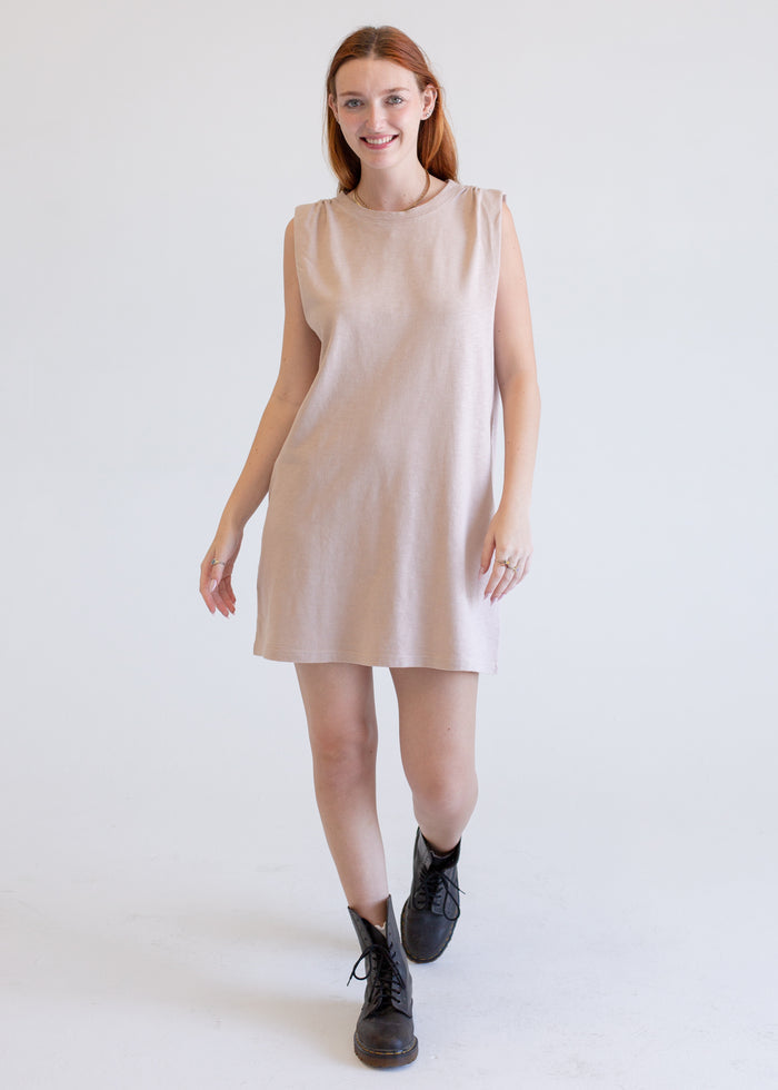 Woman wearing a beige boxy tank dress on a white background