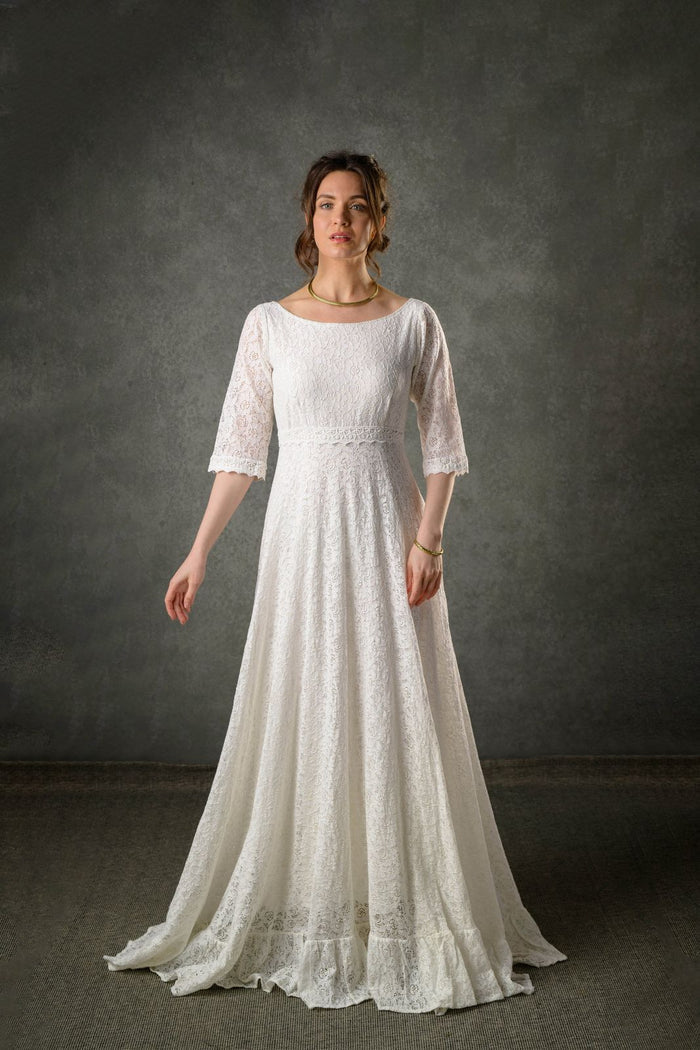 Ivory lace Celtic bridal gown with three quarter sleeves, bateau neckline and full-length flowing skirt